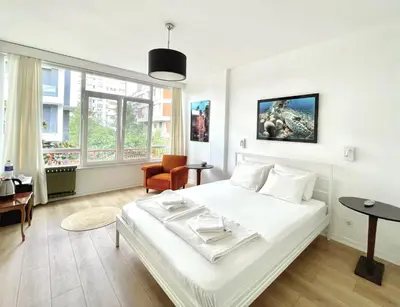 a bedroom with a large white bed and a chair at Petek Pansiyon Fenerbahce Kadikoy in Istanbul