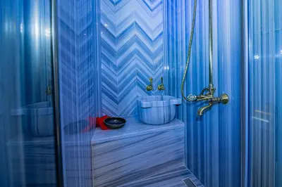 a blue bathroom with a shower and a sink at The Milltown Hotel in Istanbul