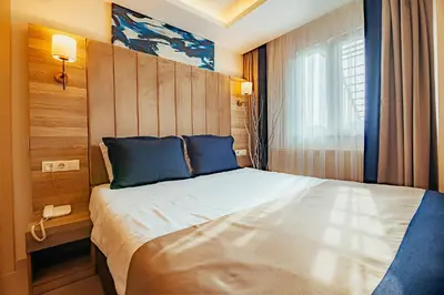a bedroom with a large bed with blue pillows at The Milltown Hotel in Istanbul