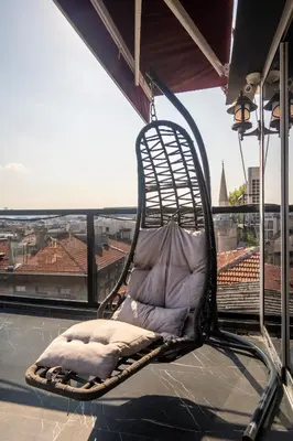 a wicker chair sitting on top of a balcony at York House İstanbul in Istanbul