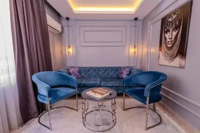 a living room with a couch and two blue chairs at Ruby Hotel in Istanbul