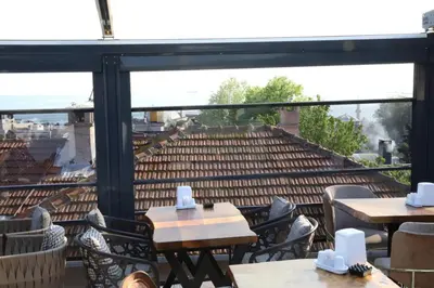 a patio with tables and chairs and a large window at Hotel Blue Ottoman in Istanbul