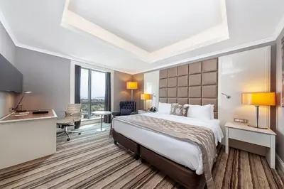 a hotel room with a large bed and a desk at Dedeman Bostanci Istanbul Hotel & Convention Center in Istanbul
