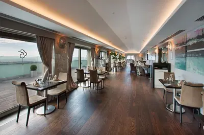 a restaurant with tables and chairs in a room at Dedeman Bostanci Istanbul Hotel & Convention Center in Istanbul