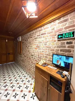 a room with a brick wall and a desk with a television at Authentic Turkish Home Suite in Istanbul