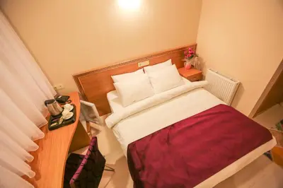 a small bedroom with a bed with a red blanket at Grand İstanbul Airport Hotel in Istanbul