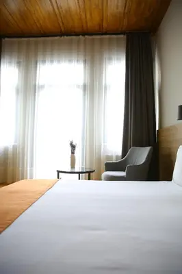 a bedroom with a bed and a chair and a window at ROCO Beyoglu in Istanbul