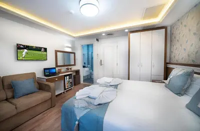 a bedroom with a large white bed and a couch at Lika Hotel - Standard Double or Twin Room in Istanbul