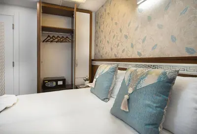 a bedroom with a white bed with blue pillows at Lika Hotel - Standard Double or Twin Room in Istanbul
