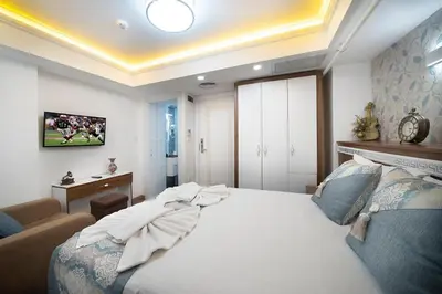 a bedroom with a large white bed and a couch at Lika Hotel - Eco Double Room in Istanbul