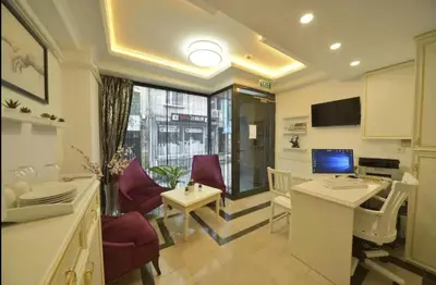 a living room with a table and chairs and a television at Lika Hotel - Beautiful Standard Double or Twin Room in Center Istanbul in Istanbul
