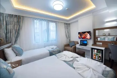 a hotel room with two beds and a television at Lika Hotel - Beautiful Standard Double or Twin Room in Center Istanbul in Istanbul