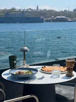 a table with two plates of food on top of the water at Pera Bosphorus Hotel in Istanbul
