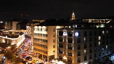 a city at night with a building with a clock on it at Pera Bosphorus Hotel in Istanbul