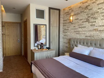 a bedroom with a bed and a brick wall at Weingart Seaside Hotel in Istanbul