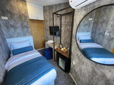 a bedroom with two beds and a mirror at Weingart Seaside Hotel in Istanbul