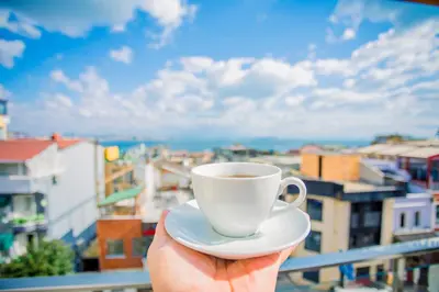 a person holding a cup of coffee on a balcony at Gülec Konak Hotel in Istanbul