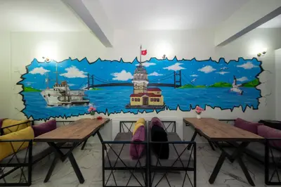 a mural on the wall of a room with two tables at XALİLA HOSTEL & CAFE, MEN's ROOM, BEST IN ISTANBUL , in Istanbul