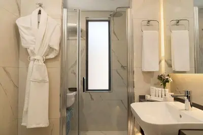 a white bathroom with a sink and a shower at Royan Hotel Hagia Sophia, a member of Radisson Individuals in Istanbul