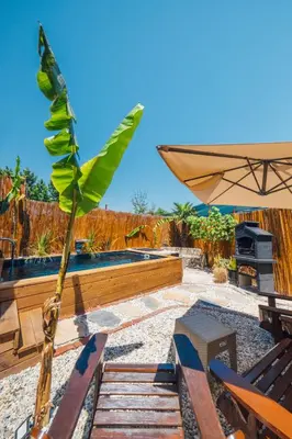 a patio with a palm tree and an umbrella at Tree Bungalov Maşukiye in Kartepe