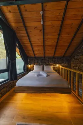 a bed in a room with a wooden ceiling at Tree Bungalov Maşukiye in Kartepe