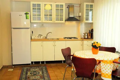 a kitchen with a table and a white refrigerator at ViP Apartments in Çekirge