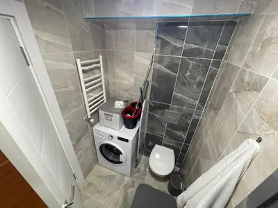 a small bathroom with a toilet and a washing machine at King Suite AE4 in Istanbul