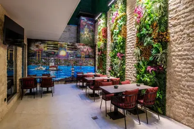 a restaurant with tables and chairs and a flower wall at Aprilis Deluxe Hotel in Istanbul