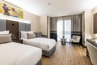 a hotel room with two beds and a chair at Aprilis Deluxe Hotel in Istanbul