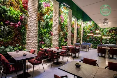 a restaurant with tables and chairs and a wall of plants at Aprilis Deluxe Hotel in Istanbul