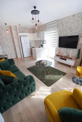 a living room with a green couch and a kitchen at King Suite BH37 in Istanbul
