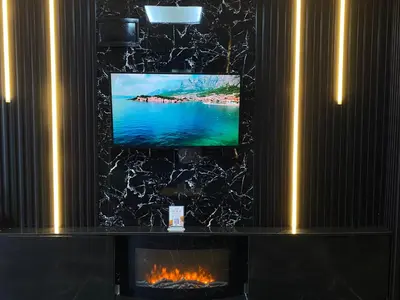 a flat screen tv on a wall with a fireplace at iNALENS AİRPORT HOTEL in Arnavutköy