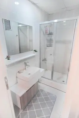 a white bathroom with a sink and a shower at King Suite SS7 in Istanbul