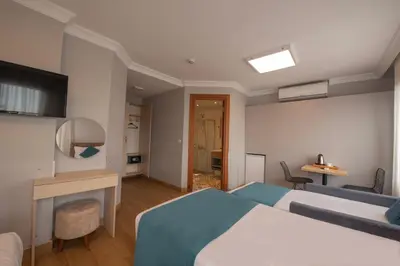 a bedroom with a bed and a desk and a television at Seven Studıos Sultanahmet in Istanbul