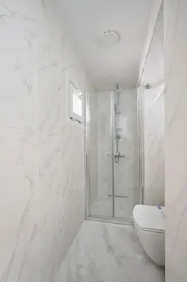 a white bathroom with a shower and a toilet at Cute Charming 1bed1bath Bebek Hidden Gem! #77 in Istanbul