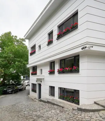 a white building with red flowers in window boxes at Modern Bright Cozy 1bed1bath Hidden Gem! #79 in Istanbul