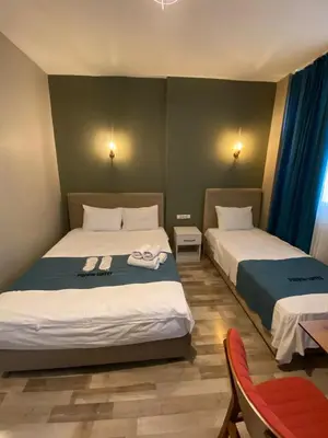 a bedroom with two beds and a table and chairs at Puffin Boutique - Istanbul in Istanbul
