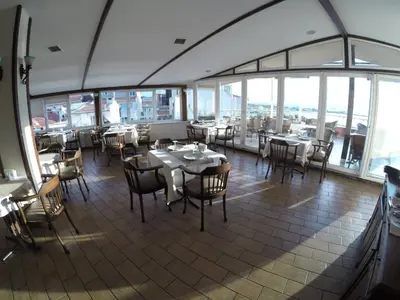 a dining room with tables and chairs and windows at deniz otel in Istanbul