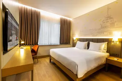 a hotel room with a large bed and a television at Radisson Hotel Istanbul Harbiye in Istanbul