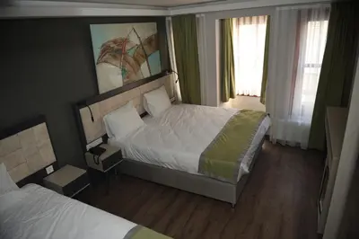 a hotel room with two beds and two windows at BEST HOTEL KADIKOY in Istanbul