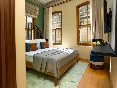 a bedroom with a bed in a room with windows at Sirin Han Hotel Old City in Istanbul