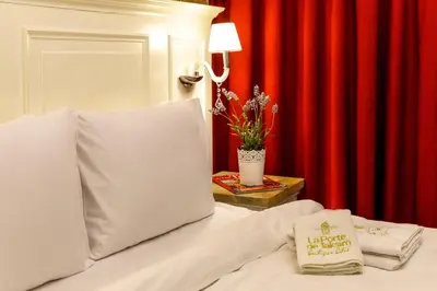 a white bed with a red curtain and a table with a pillow at La Porte de Taksim in Istanbul