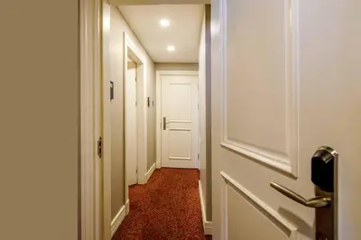 a hallway with a white door and a red floor at La Porte de Taksim in Istanbul