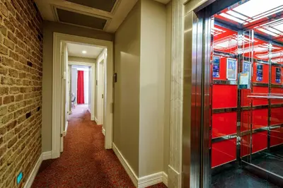 a hallway with a brick wall and red glass doors at La Porte de Taksim in Istanbul