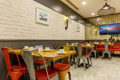 a restaurant with wooden tables and chairs and a tv at La Porte de Taksim in Istanbul