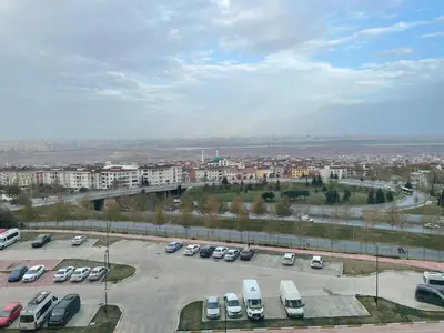 a parking lot with parked cars in a city at Agora Royal Residence in Esenyurt
