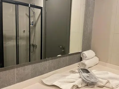 a bathroom with a sink with towels and a mirror at Agora Royal Residence in Esenyurt