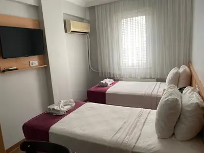 a hotel room with two beds and a tv at HOTEL ÖZSEFA in Istanbul