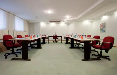 a conference room with long tables and red chairs at SEFA HOTEL 1 ÇORLU in Corlu