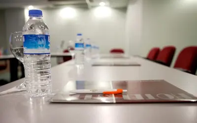 a bottle of water sitting on a table with a laptop at SEFA HOTEL 1 ÇORLU in Corlu